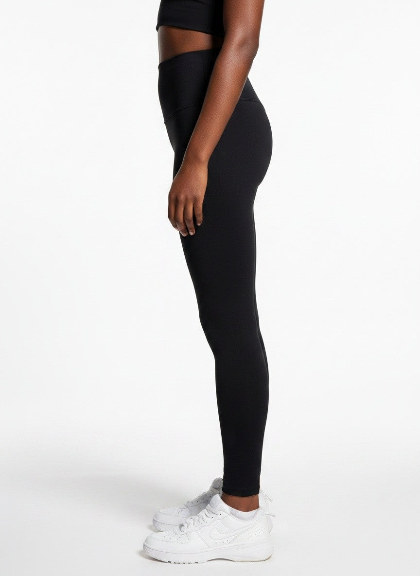Women’s black high-waisted gym leggings with slim fit stretch fabric, side view activewear.


