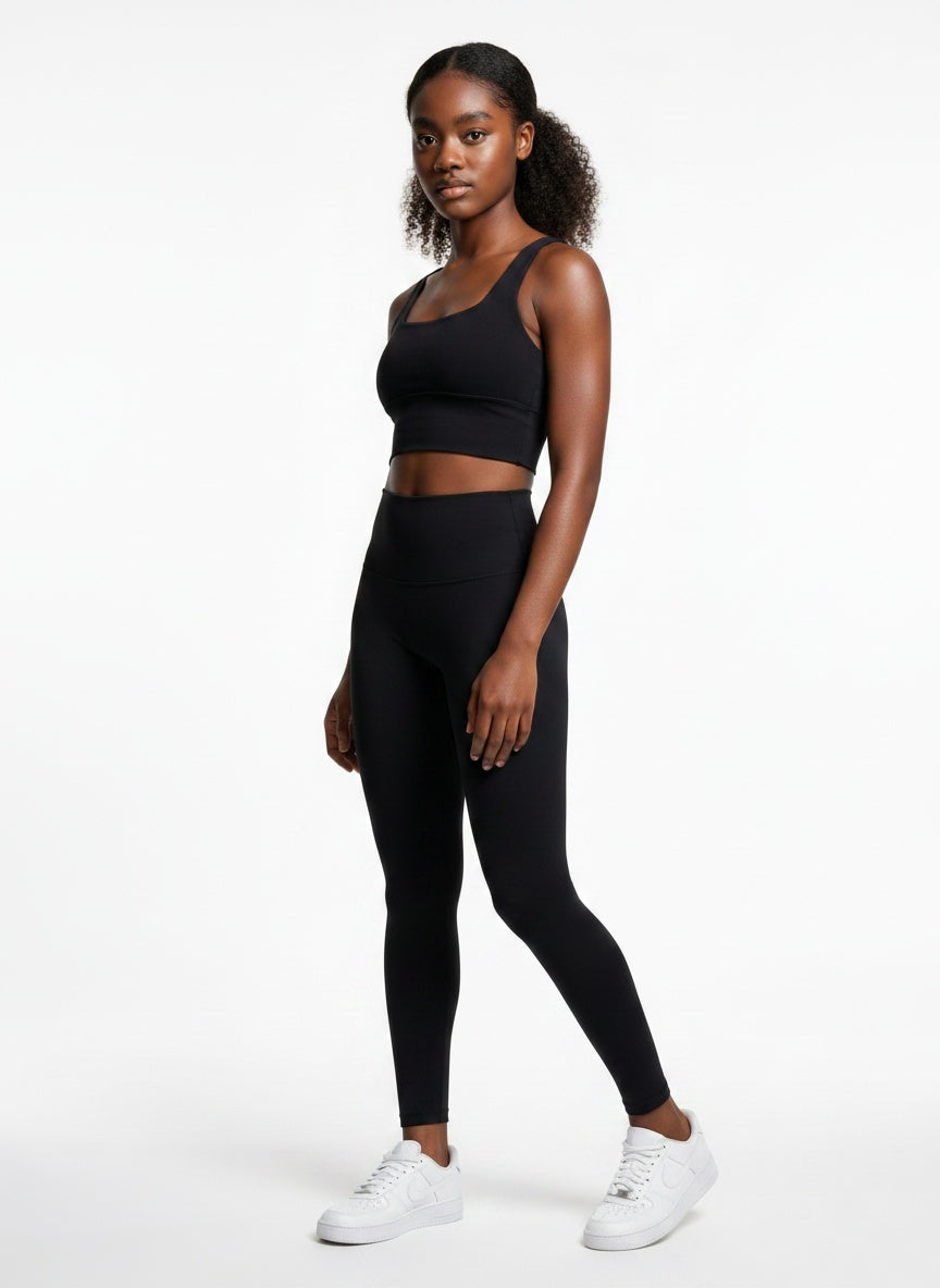 Woman wearing a black athletic outfit on a white background